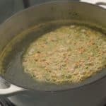 Add coriander and garlic to the molokhia and stir