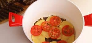 Put some grape leaves in the first layer, then add the potato slices and tomato slices
